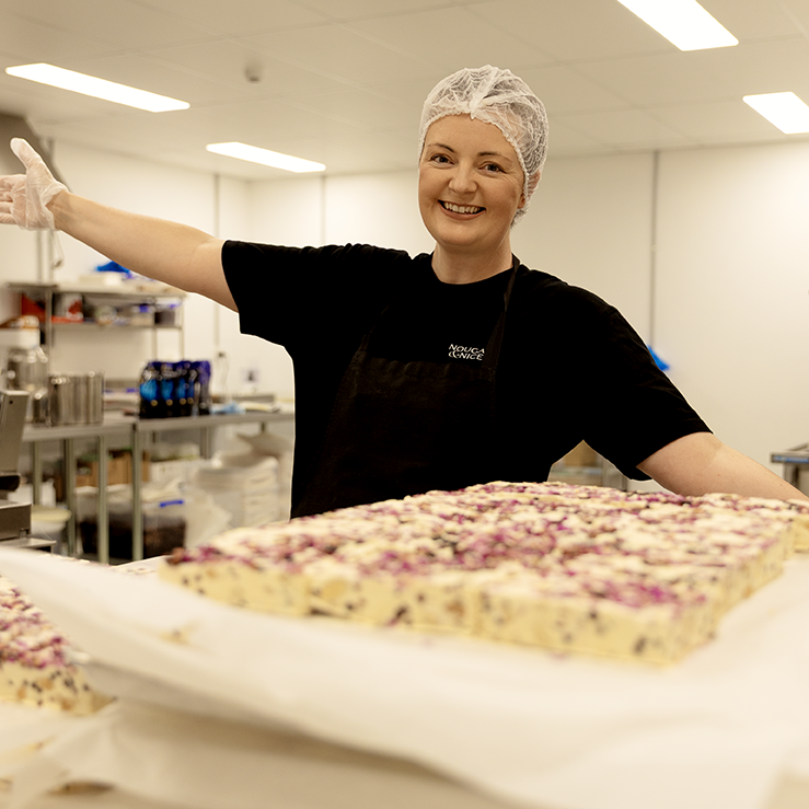 Person in a food processing facility holding nougat